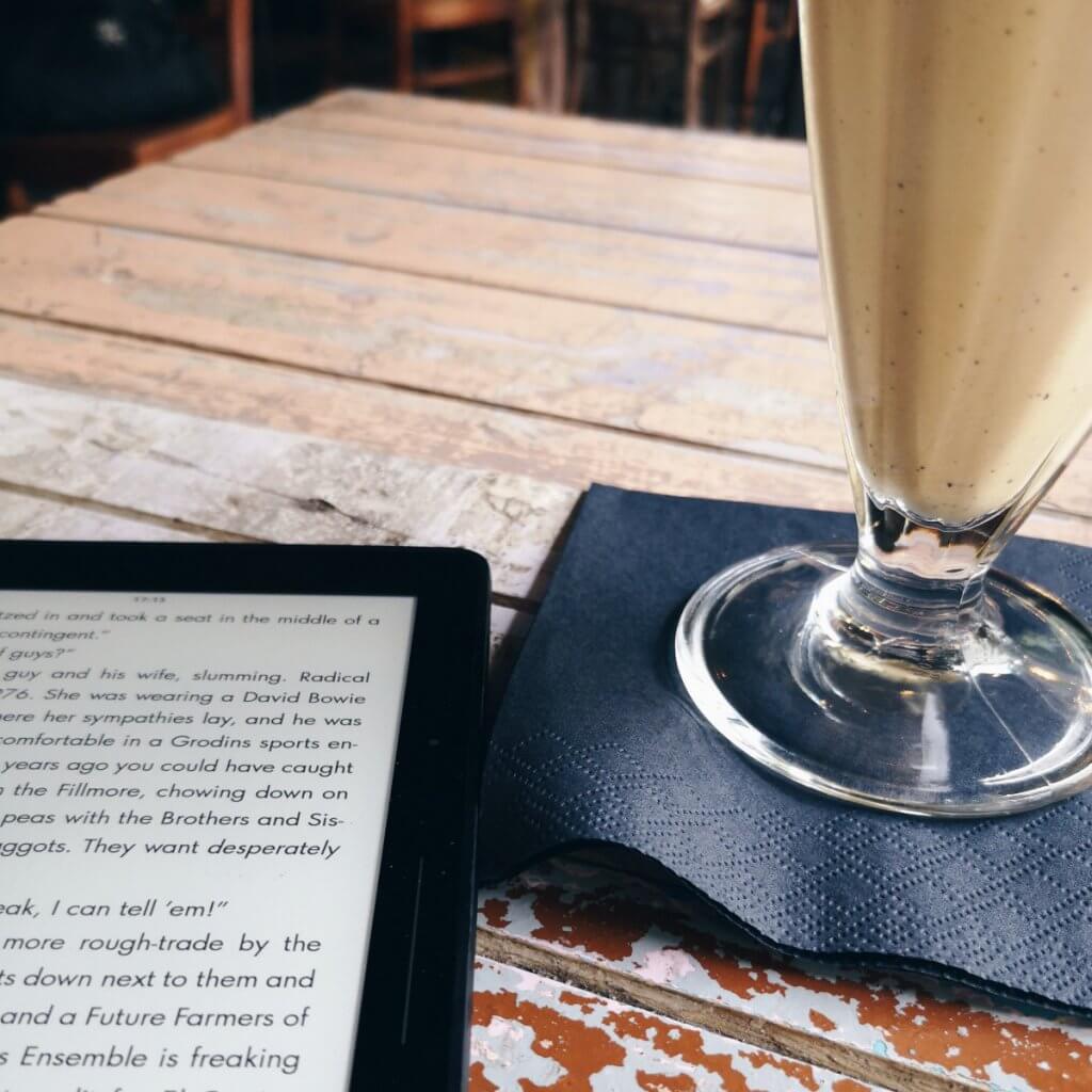 Kindle und Milkshake im Café
